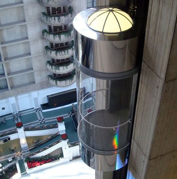 Sleek cylindrical capsule lift in a modern lobby